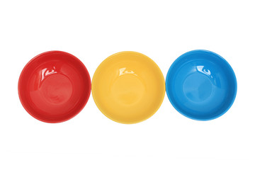 Row with three colorful bowls isolated over white