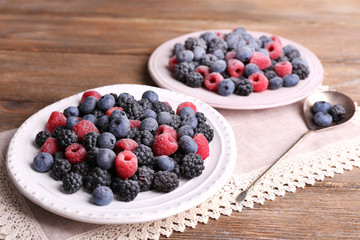 Iced berries on plates, on wooden background