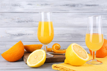 glasses of juice with fresh fruits on grey wooden table