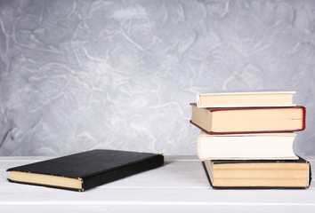 Books on wooden table on light background
