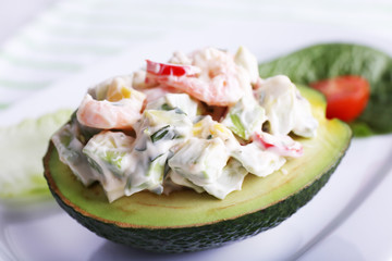 Tasty salad in avocado on plate close-up