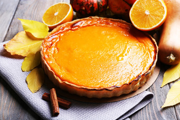 Homemade pumpkin pie on napkin, on wooden background