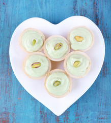 Tartlets with greens and sauce on plate on table