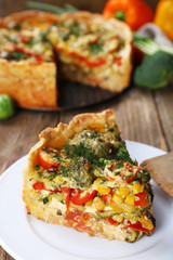 Piece of Vegetable pie with broccoli, peas, tomatoes and cheese