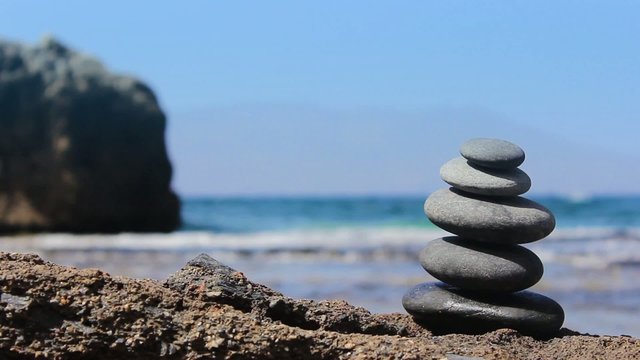 Stones pyramid on the beach. Ocean in the background