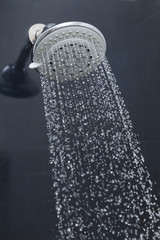 shower head in bathroom with water drops flowing