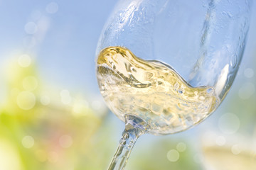 Close up of pouring white wine in a glass - obrazy, fototapety, plakaty