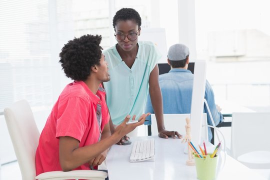 Young creative team speaking at desk