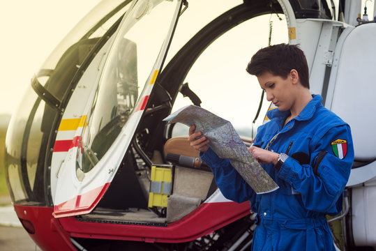 Young woman helicopter pilot reading map.