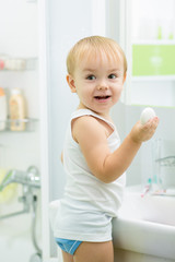 child toddler washing hands with soap in bathroom