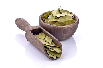 Liście laurowe z drewnianą łyżką i miską