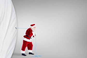 Composite image of santa claus pulling rope