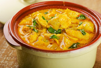 Curry in   clay bowl on a wooden table.