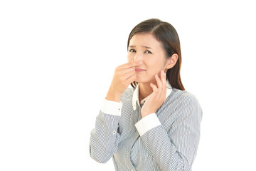 鼻をつまむ女性