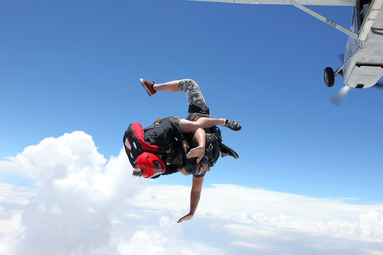 Two skydivers jump from an airplane