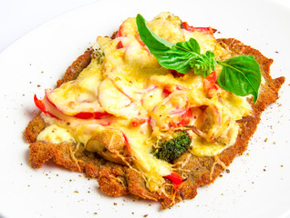 Crispy veal schnitzel with cheese, tomatoes, peppers, broccoli
