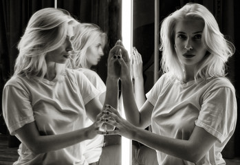 sexy girl in white t-shirt and her reflection in mirror table