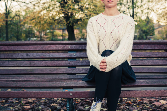 Young woman sitting on park bench