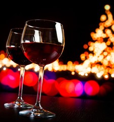 two red wine glass against bokeh lights tree background