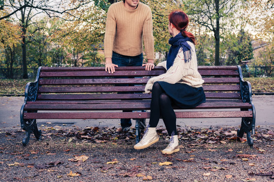 Young man and woman talking in park