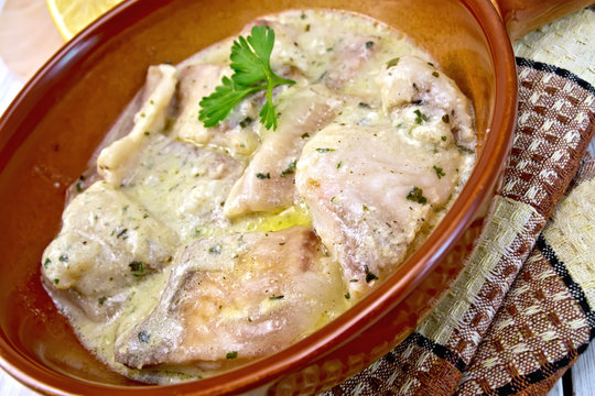 Fish stew in creamy sauce on ceramic pan