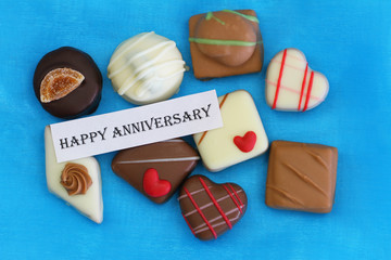 Happy Anniversary card with chocolates on blue background