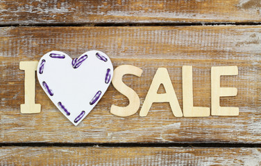 I love sale sign on rustic wooden surface