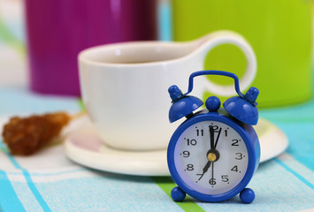 Fototapeta na wymiar Miniature clock showing 7 and cup of coffee