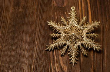 Golden snowflake on a wood