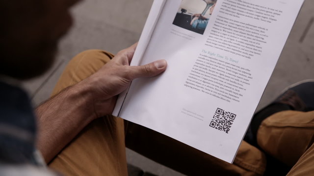Man scanning qr code from magazine with smartphone
