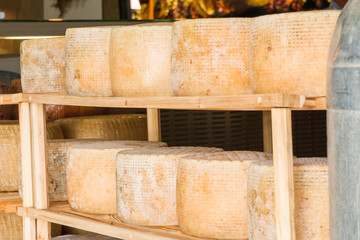 series of round forms of aged cheese for sale in the local marke