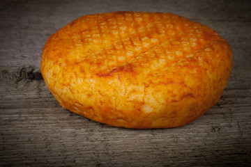 head hard cheese with paprika on an old wooden table. Tinted