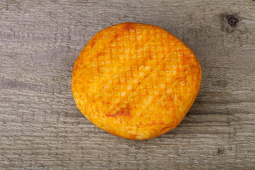 head hard cheese with paprika on an old wooden table