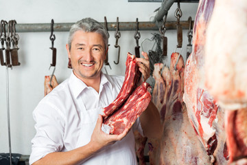 Butcher Holding Fresh Meat In Slaughterhouse