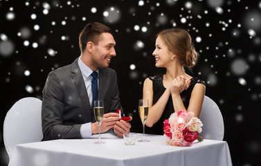 smiling couple with red gift box at restaurant