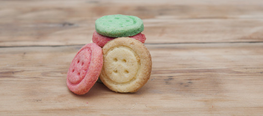 Obraz na płótnie Canvas Multicolored sugar cookies on wooden background