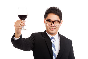 Asian businessman cheers with glass of red wine