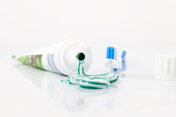 ausgedrückte Zahnpasta vor Tube und Zahnbürste