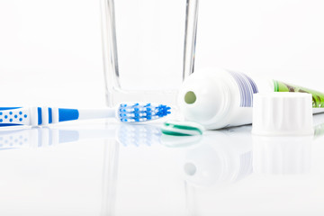Zahnbürste, Zahnpaste mit Tube und Glas Wasser