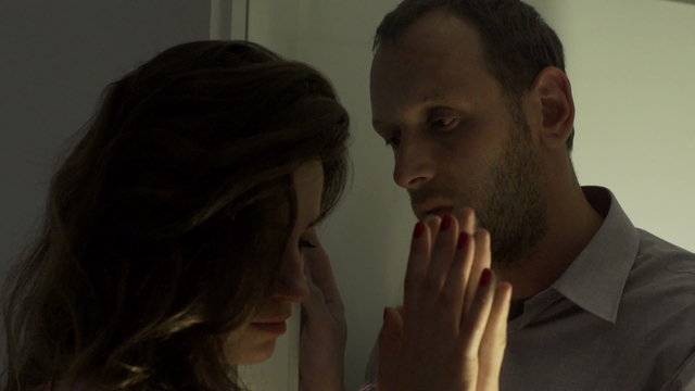 Couple separate from each other by window and woman leaving