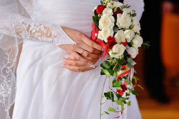 graceful hands of the bride and the bridal bouquet