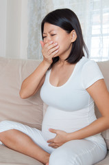 Asian pregnant woman suffering from vomiting with nausea