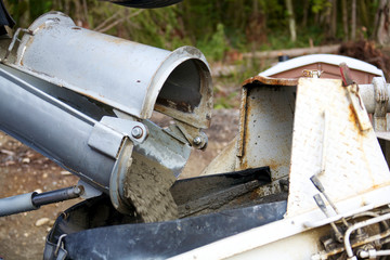 Concrete being poured from a truck into a concrete pump 