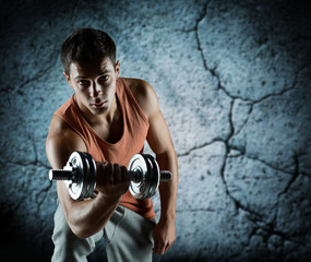 young man with dumbbell flexing biceps