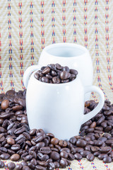 close up of coffee beans and a cup full of coffee
