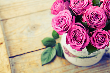 Bouquet of beautiful pink roses on wooden background, toned.