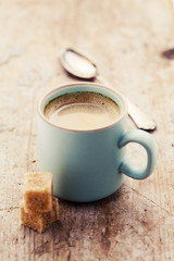 Cup of coffee on wooden table, toned