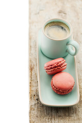 Cup of coffee and macaroons on wooden table.