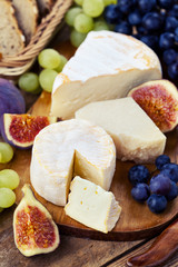 Cheese plate. Variety of cheese sorts with grapes and figs