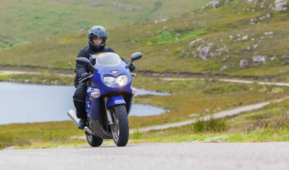 Obraz premium Motocyklista w Scottish Highlands